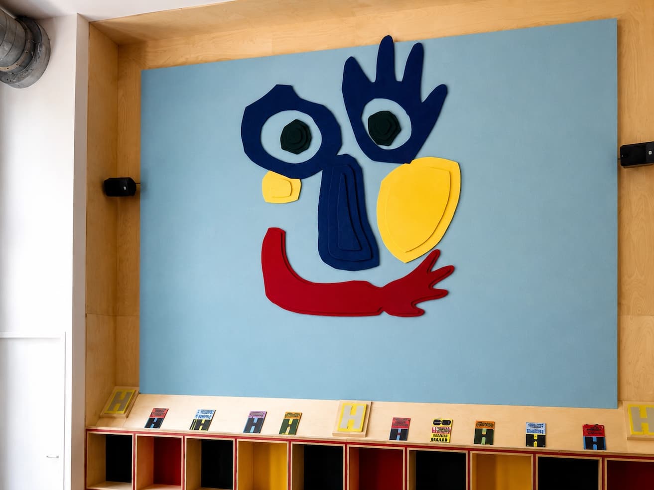 Detail van PETfelt logo Kareltje op lichtblauw wandpaneel