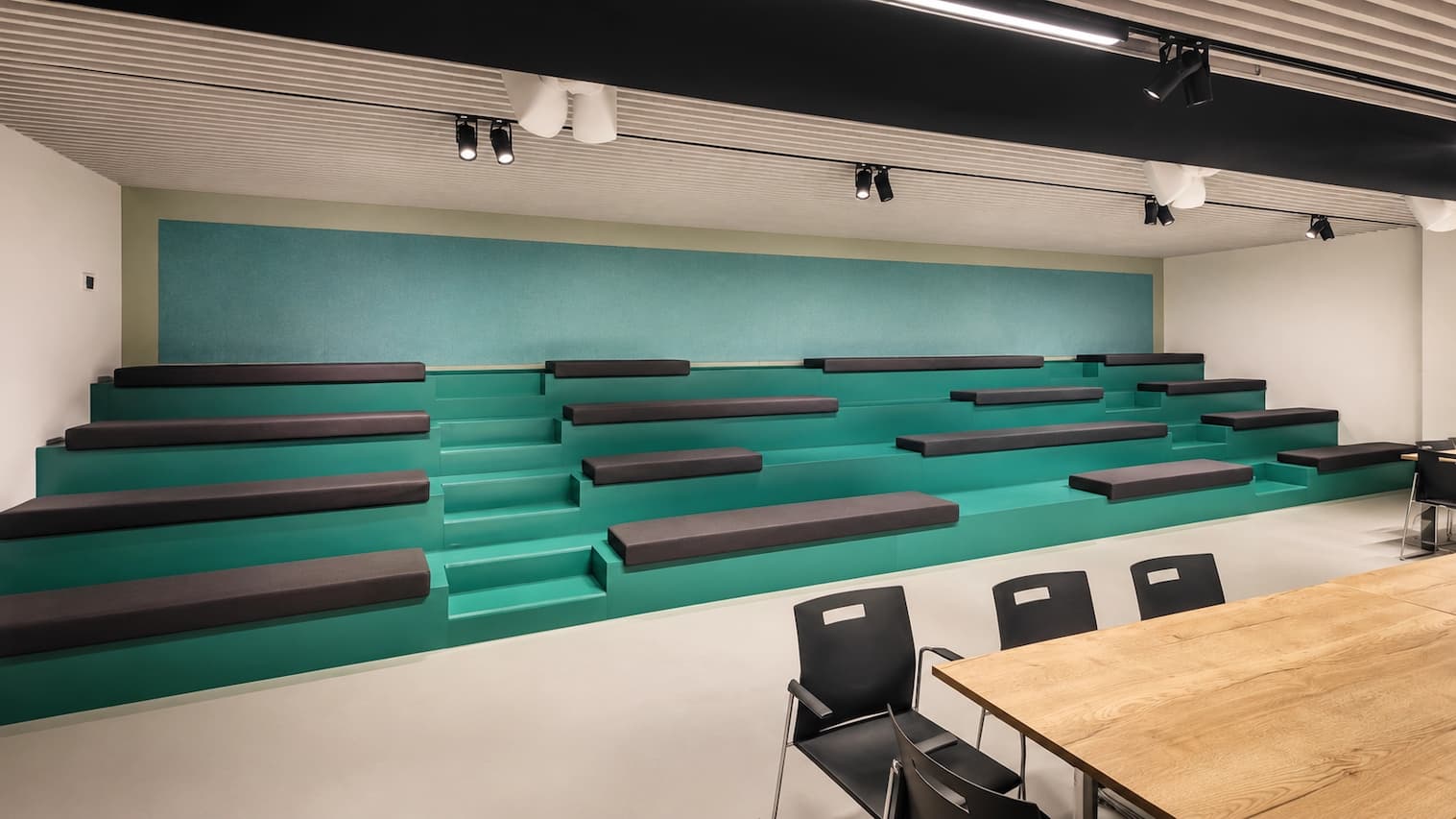 Auditorium in verzorgingstehuis met PETfelt wandpanelen achter groene tribune